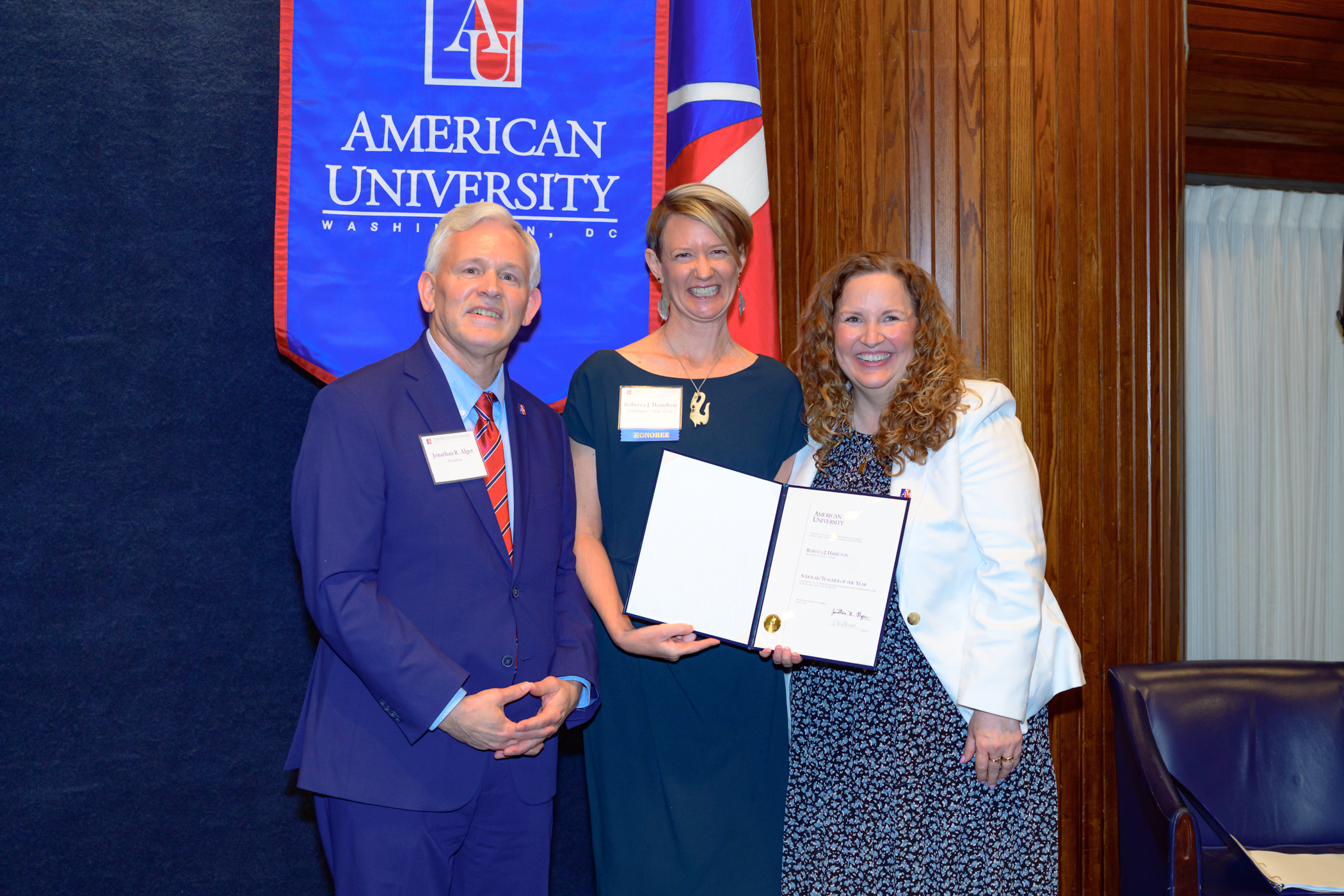 Professor Rebecca Hamilton receives the Scholar of the year award from President Jon Alger and Provost Vicky Wilkins